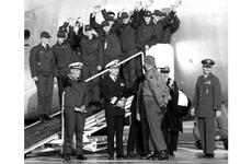 Cmdr. Lloyd Bucher, front left, and USS Pueblo crew members wave to the crowd as they prepare to leave Kimpo Air Base.