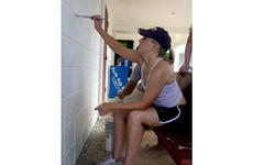 Petty Officer 3rd Class Deanna Mentzel paints the community center in Agat, Guam, during a cleanup project Saturday.