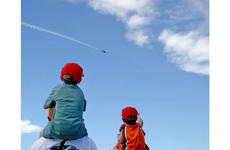 Hayden Froehlich, 5, left, was among the children using the shoulders of adult friends and parents to get a bird's-eye view of the Thunderbirds practice show on Saturday