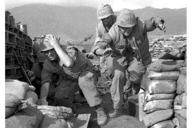 While mortar and artillery shells explode around them, U.S. Marines scramble for safety in a bunker at the Khe Sanh base.