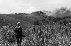 9th Regiment Marines advance in 1967 toward North Vietnamese hilltop positions under cover of Marine air strikes.