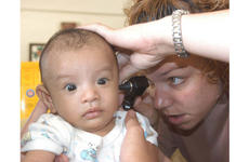 Army Capt. Robyn Brand, a pediatrician from Hawaii, checks out an infant during a MEDCAP as part of Balikatan 2003 in the Philippines.