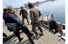 U.S. Navy divers discuss how to best survey the Hachinohe City port on Friday.