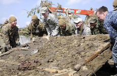 Army veteran Matt Szymanski, fifth from left with the U.S. flag patch on his hat, helps a group of Marines, airmen and sailors attempt to lift a giant piece of debris while helping clean Noda Village, about a two-hour drive from Misawa Air Base, Japan, during a March 29 trip.