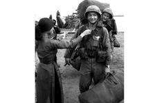 A soldier is given a flower by a Vietnamese girl as the 196th Light Infantry Brigade comes ashore near the end of a long journey from Fort Devens, Mass. in August, 1966.