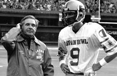 Notre Dame coach Dan Devine talks with East quarterback Mark Herrmann of Purdue during the Japan Bowl.