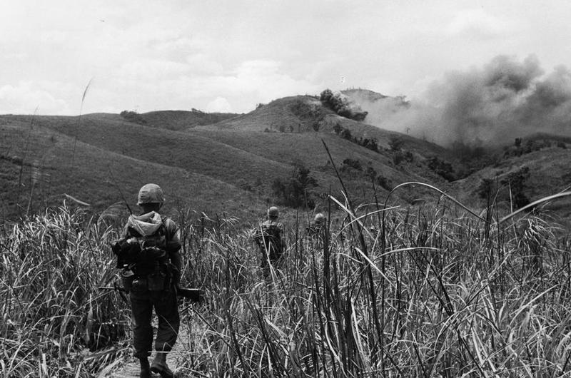 9th Regiment Marines advance in 1967 toward North Vietnamese hilltop positions under cover of Marine air strikes.