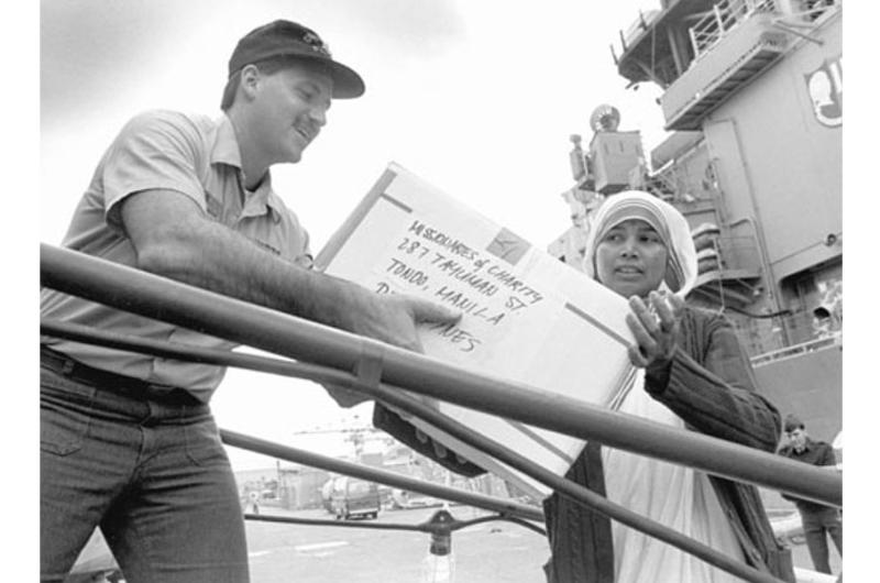 Petty Officer 2nd Class Robert Fabrizio and Sister Lily Bumdum of the Missionary Sisters of Charity help load relief supplies onto the USS Fife at Yokosuka Naval Base in November, 1988.