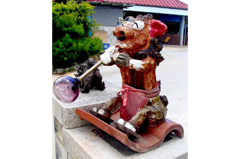 A glassblowing shishi lion, Okinawa’s traditional good fortune sculpture usually placed at the entrance to homes and businesses, greets visitors to the Mid-Air Glass Blowing Studio Rainbow in Yomitan, Okinawa.