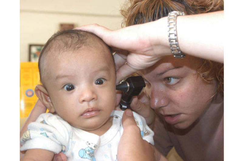 Army Capt. Robyn Brand, a pediatrician from Hawaii, checks out an infant during a MEDCAP as part of Balikatan 2003 in the Philippines.