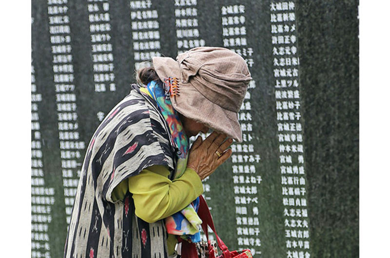A woman prays for loved ones lost in the Battle of Okinawa during the annual Irei no Hi ceremony at Peace Memorial Park in Okinawa, Japan, June 23, 2019.