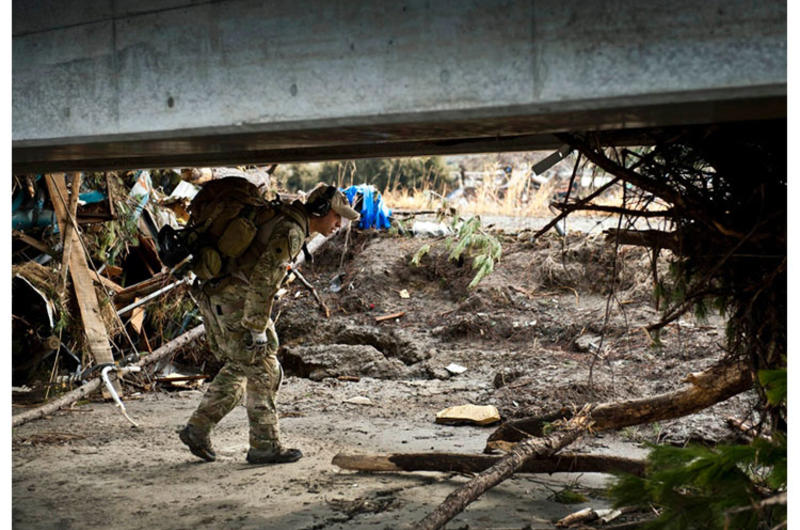 An airman looks for trapped survivors at Sendai Airport, Japan, March 16, 2011, days after a 9.0-magnitude earthquake and related tsunami stuck the region.