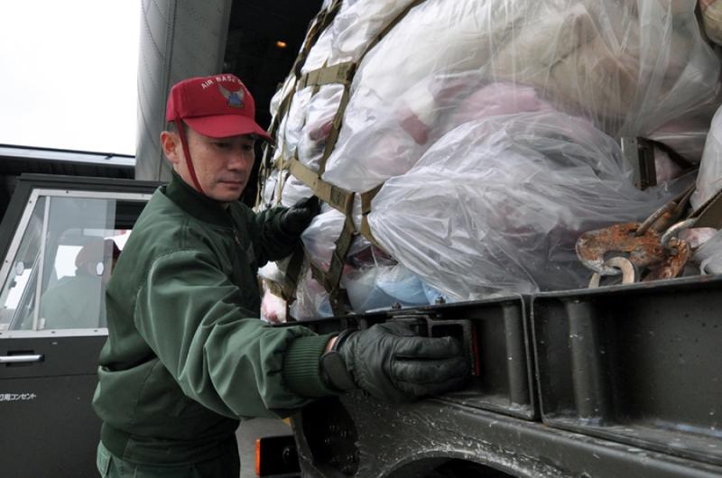 First Sgt. Yoshihiro Kamamoto, a member of the Japan Air Self-Defense Force, helps unload a pallet of donated blankets from a U.S. Navy C-130 on Sunday at Misawa Air Base, Japan.