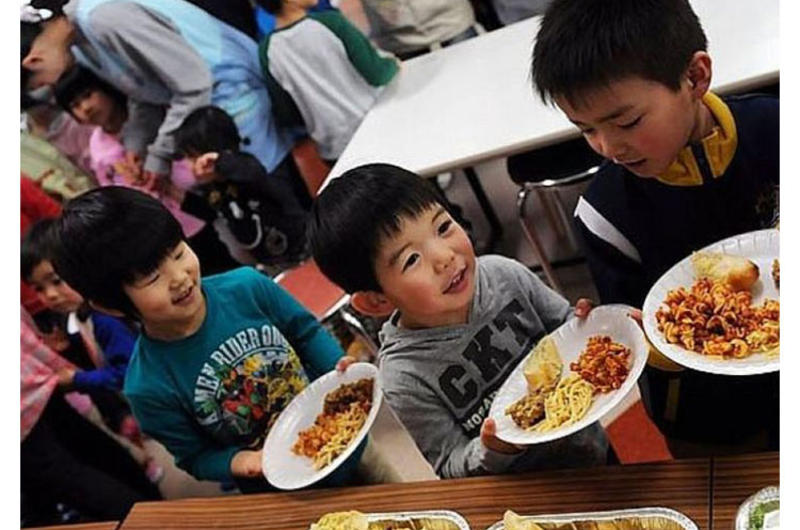 Children at Bikou-en Children's Care House wait in line for a home-cooked meal delivered March 27 by sailors from Naval Air Facility Misawa.
