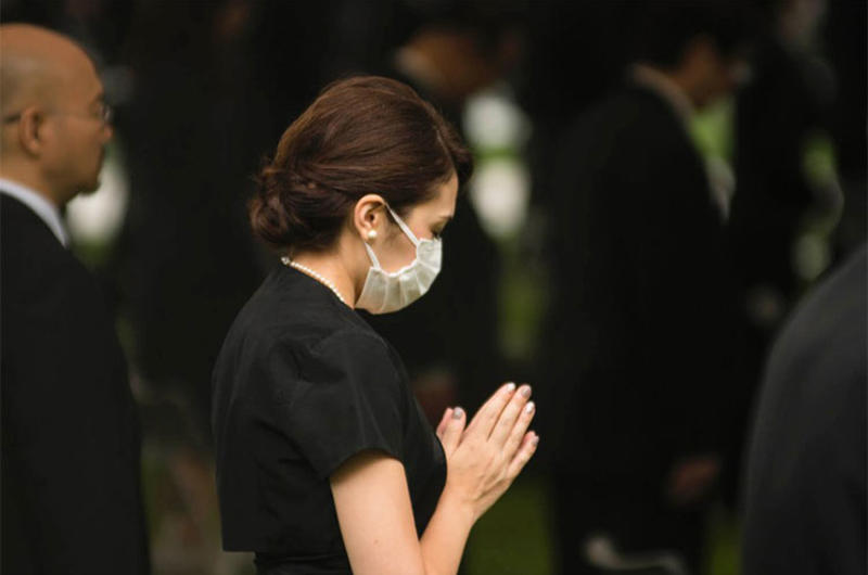 A woman prays at Hiroshima Peace Memorial Park, Thursday, Aug. 6, 2020, during a ceremony marking the 75th anniversary of the atomic bombing.