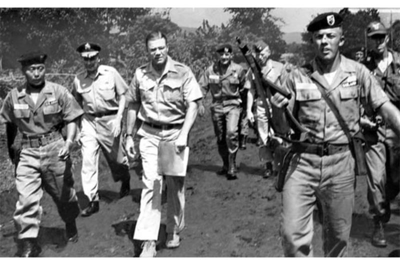 Pfc. Frank Orians of Grand Rapids, Mich., escorts Secretary of Defense McNamara and his entourage on a walk into an unsecured jungle area in Vietnam.