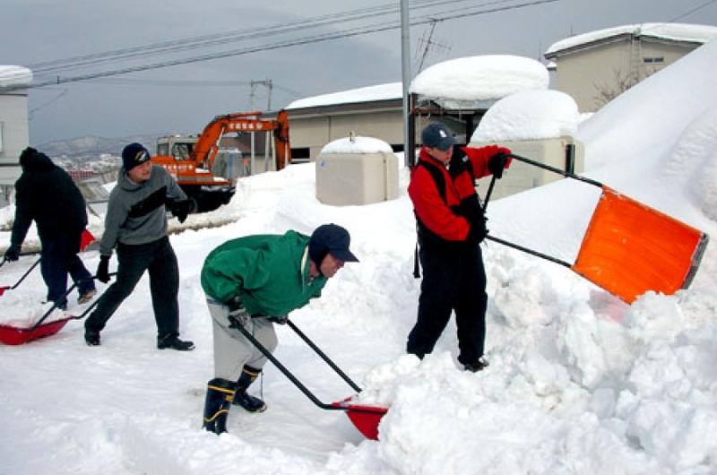 Sailors from the Yokosuka, Japan-based USS John S. McCain help dig out a school for the mentally challenged Tuesday in the city of Otaru on Japan's northern island of Hokkaido.