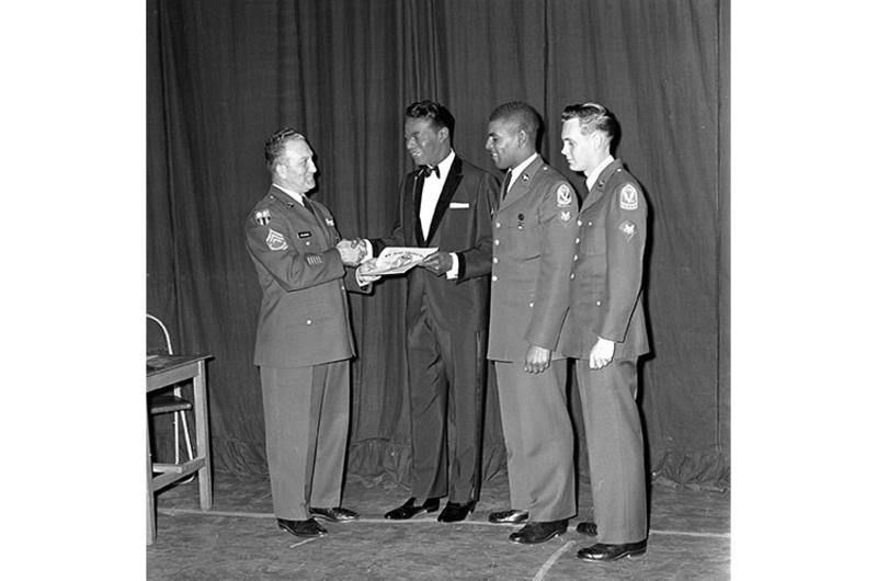 Jazz singer and pianist Nat King Cole - currently on a Southeast Asia tour - is made a honorary Army recruiter during his visit to Korea.
