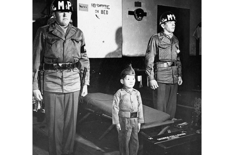 M/Sgt. Yo-Yo (center) was not always the sharp soldier he is in the picture. No, as a matter of fact, the little Korean orphan was found freezing to death on the streets of Seoul two-months ago.