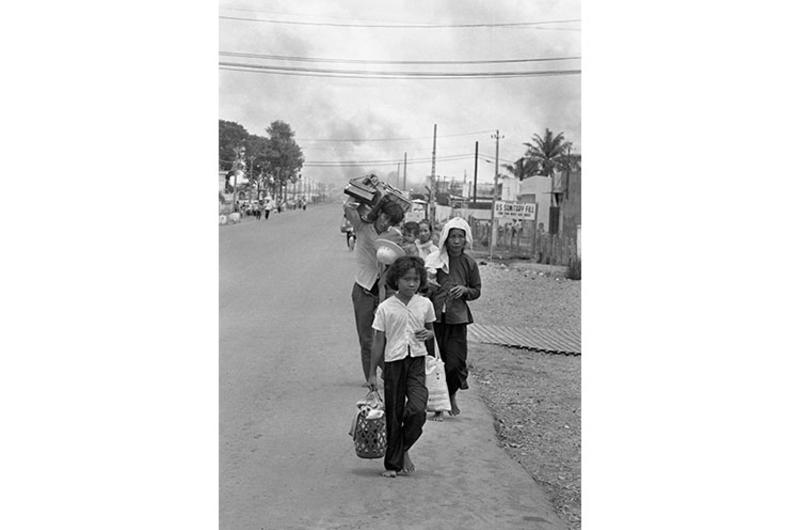Refugees flee burning buildings near Tan Son Nhut. Viet Cong and North Vietnamese forces started shelling more than 120 provincial capitals, towns and allied military installations across South Vietnam  and battled governement and U.S. troops inside the capital Saigon, May 5th.
