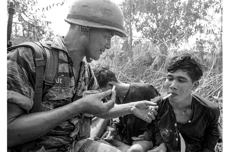 A South Vietnamese marine gives a cigarette to a Viet Cong prisoner in the aftermath of a battle 65 miles southwest of Saigon.