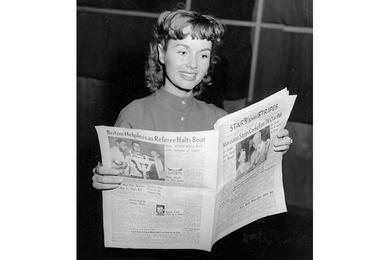 Actress Debbie Reynolds flips through the Stars and Stripes newspaper. 