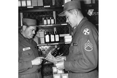 STOCK IS CHECKED at the 6th Medical Depot, Ascom, Korea, by Sgt. Jose Burgos (left), assistant non-commissioned officer in charge of the loose issue section, and Sgt. Felipe Borrios (right), stock checker.
