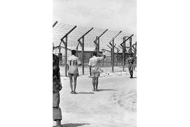Viet Cong prisoners pass through the prison camp.