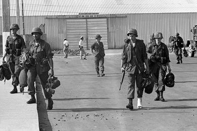 Sp5 Heinz Huder of Palm Bay, Florida - his right foot in a cast - walks at an unidentified airport in South Vietnam.