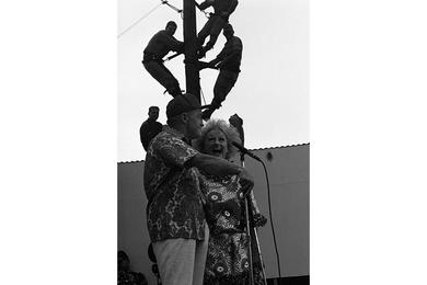 Bob Hope and Phyllis Diller performing with soldiers watching from a mast.